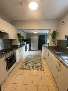 una grande cucina con armadi bianchi e pavimento piastrellato di Allon Manor De'Grey a Hull