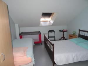 a room with two beds and a table and a chair at Gîte Thevenin in Le Châtelet