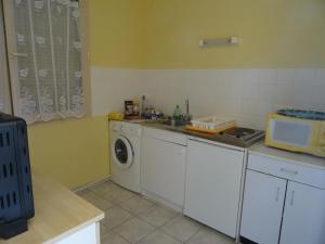a kitchen with a washing machine and a sink at Gîte Thevenin in Le Châtelet