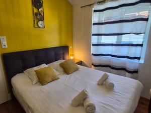 a bedroom with a white bed with two pillows at L'industriel - Lourdes Centre in Lourdes