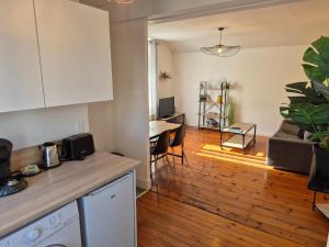 a kitchen and a living room with a table at L'industriel - Lourdes Centre in Lourdes