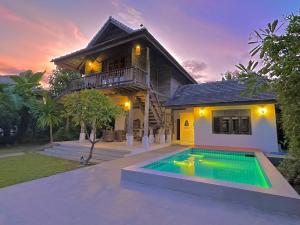 a house with a swimming pool in front of a house at baanchandra in Chiang Mai