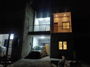 een auto die 's nachts voor een gebouw geparkeerd staat bij Todkars Villa in Kolhapur