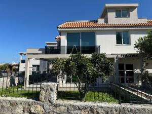 a large white house with a stone wall at Veray Homes, Alsancak in Ayios Dhometios