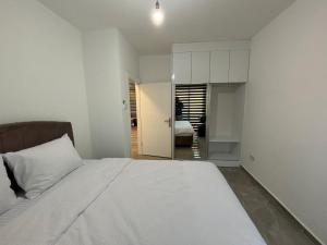 a bedroom with a large white bed and a room at Veray Homes, Alsancak in Ayios Dhometios