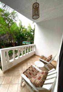 een veranda met een bank en een stoel op een patio bij Elala Studio Homes in Diani Beach