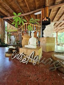 pokój z Buddą siedzącym na łóżku w obiekcie EntreAguas Ecolodge w mieście Doradal