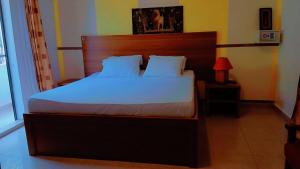 斯基灵角Hotel La Marsu的卧室里有一张带木质床头板的大床