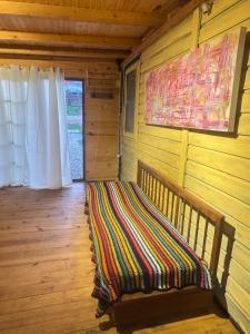a wooden room with a bench with a blanket on it at Amanda Relax and nature beautiful beach in Playa Hermosa