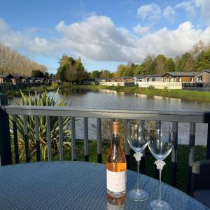 a bottle of wine sitting on a table with two wine glasses at White Swan Lodge in Allerthorpe