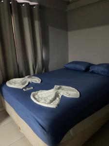 Casa Confortável e Prática de 1 Quarto acomoda até 5 pessoas في فوز دو إيغواسو: سرير عليه شراشف ومناشف زرقاء