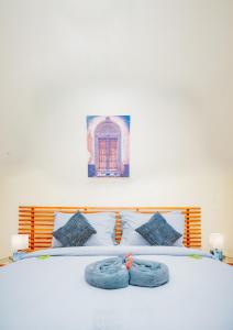 a bedroom with a bed with blue towels on it at Roots and Waves Apartment in Zanzibar City