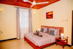 a bedroom with a bed and a ceiling fan at Roots and Waves Apartment in Zanzibar City +13 photos
