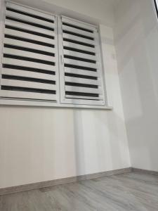 a white wall with a window in a room at Basarab Residence in Chişinău +2 photos