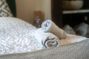 a stack of towels sitting on a bed at Cottage, Lodge & Spa 54 in Prouilly
