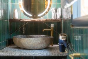 a bathroom with a stone sink and a mirror at Cottage, Lodge & Spa 54 in Prouilly