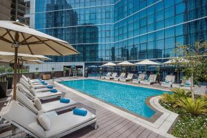a swimming pool with lounge chairs and an umbrella at TRYP by Wyndham Dubai in Dubai
