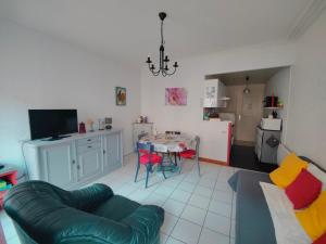 a living room with a couch and a table at La Fontaine- Douceur, Centre Historique et Charme in Plombières-les-Bains