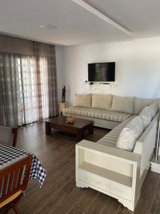 Una sala de estar con un sofá y un televisor. en Duplex Rim ,with swimming pool, en Ḩammām al Ghazzāz 38 fotos más