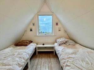 two beds in a room with a window at M398-Gedser-Gedser-Feriepark-32 in Gedser