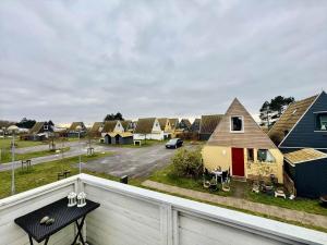 a balcony with a black table and houses at M398-Gedser-Gedser-Feriepark-32 in Gedser