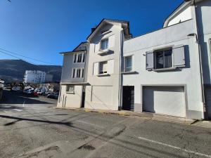 a white building on the side of a street at L'industriel - Lourdes Centre in Lourdes