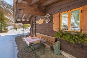 a cabin in the snow with a picnic table outside at Bergkristall Hütte in ruhiger Panoramalage in Sankt Sigmund im Sellrain