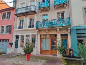 an apartment building with blue balconies on a street at La Fontaine- Douceur, Centre Historique et Charme in Plombières-les-Bains