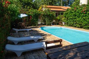 a swimming pool with chairs and a bench next to it at Pousada do Peralta in Bonito