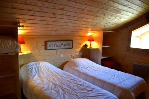 1 dormitorio con 2 camas en una cabaña de madera en Chalet le Lagopède, en La Joue du Loup