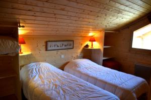 ラ・ジュー・デュ・ルーにあるChalet le Lagopèdeのログキャビン内のベッドルーム1室(ベッド2台付)