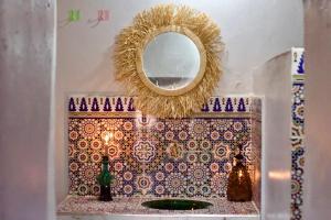 a mirror on a wall above a counter with a sink at Camp Ayour Mhamid in Mhamid +61 photos