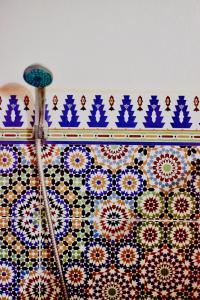 a tiled wall with blue and white patterns on it at Camp Ayour Mhamid in Mhamid