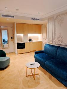 a living room with a blue couch and a table at Mode Paris Aparthotel in Paris