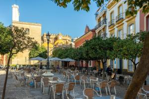 an empty street with tables and chairs and buildings at Duque Center Premium Suites in Seville