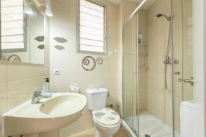 a bathroom with a sink and a toilet and a shower at Duque Center Premium Suites in Seville +22 photos