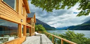 a house with a deck with a view of a lake at Aguas Arriba Lodge in El Chalten