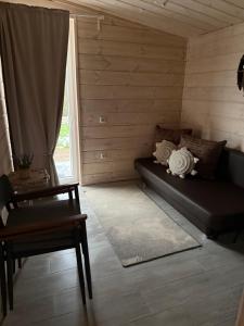 GaylyunayObuoliu Sala COZY HOUSE on the Apple Island的一间配有沙发、桌子和窗户的客房