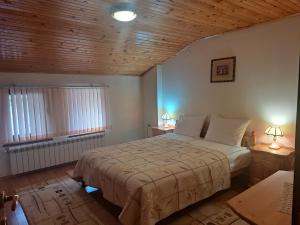 a bedroom with a bed and two lamps and a window at Guest House Benita in Devin