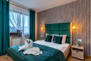 una camera da letto con un letto con un asciugamano a forma di cigno di Rolicek 4 Seosons Apartments a Zakopane