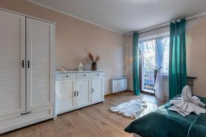una camera da letto con tende verdi, un letto e una finestra di Rolicek 4 Seosons Apartments a Zakopane Altre 69 foto