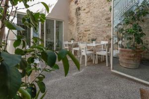 eine Terrasse mit Tisch und Stühlen und einer Backsteinmauer in der Unterkunft Le Contrade - Dimora nel Borgo in Santarcangelo di Romagna