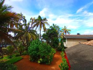 a view of a yard with palm trees and a house at Allan Guest Mirissa in Bandaramulla
