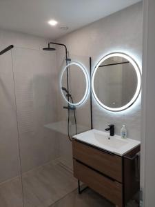 a bathroom with a sink and a mirror at Gold Residence Apartman in Hajdúszoboszló