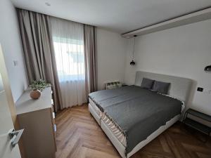 a bedroom with a bed and a large window at Gold Residence Apartman in Hajdúszoboszló