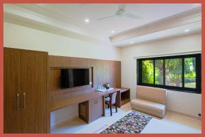a room with a tv and a desk with a chair at Hotel Royal Shivangi Palace - Near Holy Cross Hospital , Masuri Canal Bridge , mussoorie in Dāsna