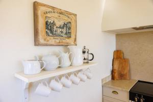 a shelf with white cups and a picture on the wall at Villa Miradou in Saint Paul de Vence