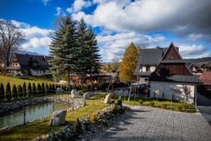 una casa con un laghetto di fronte a una casa di Rolicek 4 Seosons Apartments a Zakopane
