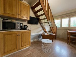 una cocina con armarios de madera y una escalera de caracol en Appartement residence bec aigle, en Le Lioran 15 fotos más