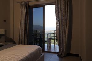 een slaapkamer met een bed en uitzicht op een balkon bij Daros International Hotel in Arba Minch